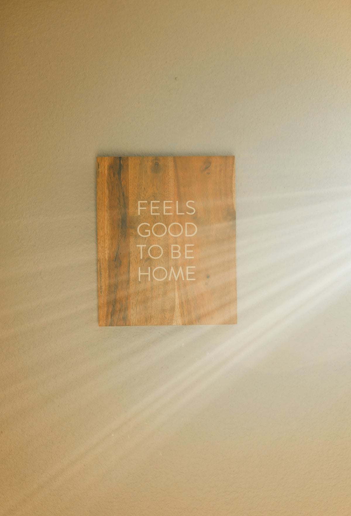 a wooden sign that reads feels good to be home