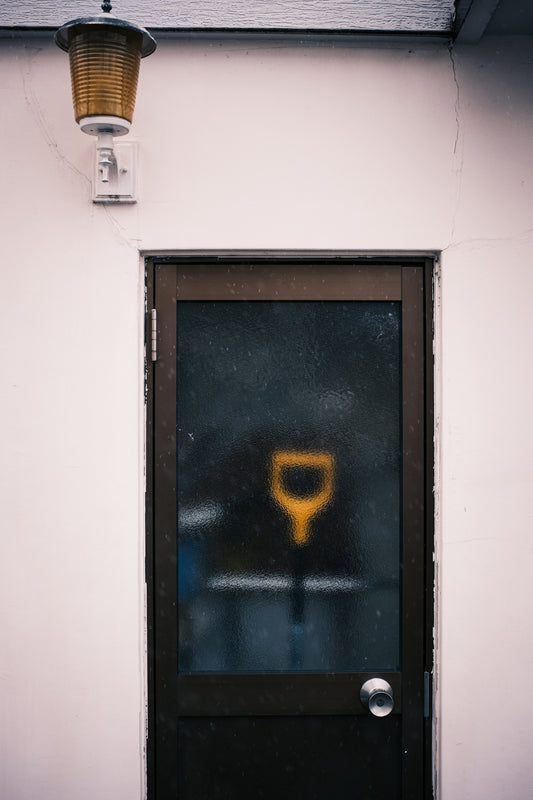 A frosted glass door with a yellow shovel symbol.