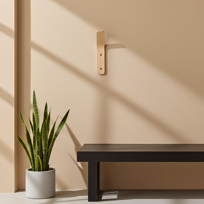 Potted plant and black bench against a beige wall with a wooden bracket.