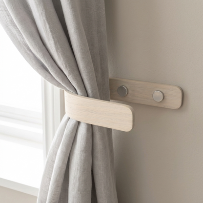 Curtain tie-backs on a gray curtain with a neutral wall background