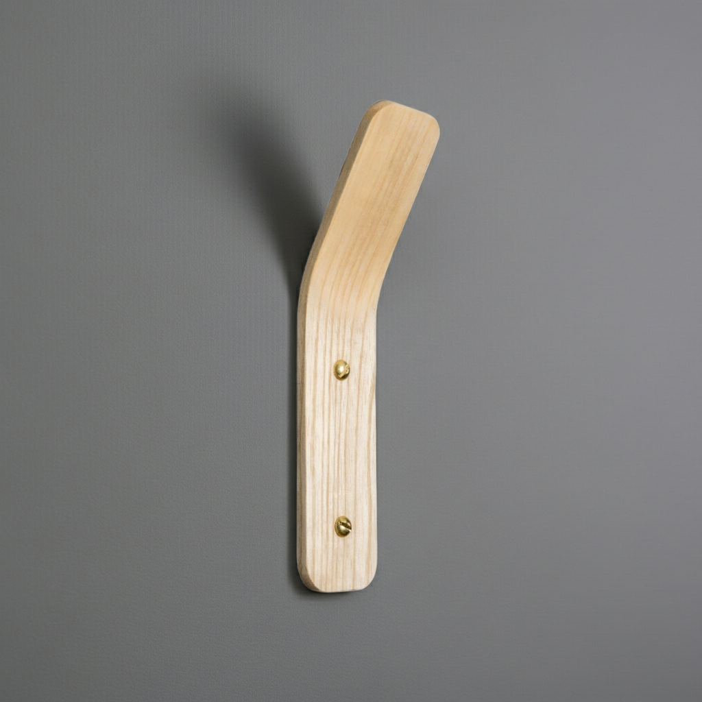 Wooden wall hook with two brass screws on a gray background